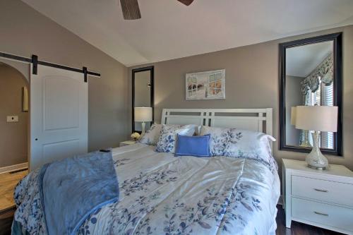 a bedroom with a bed with a blue comforter and a mirror at Hot Tub and Views Waterfront Escape in Hot Springs in Hot Springs