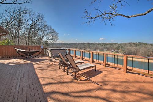 three chairs and a table on a deck with a view of the water at Hot Tub and Views Waterfront Escape in Hot Springs in Hot Springs