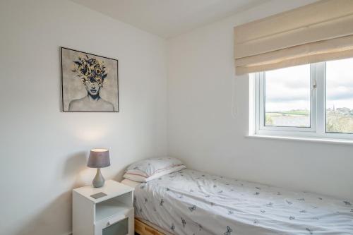 a bedroom with a bed and a window at Shrimper's Cottage in Wadebridge