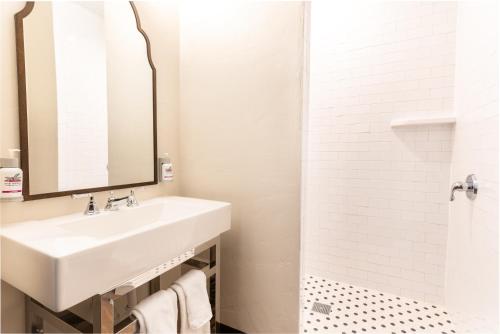 La salle de bains blanche est pourvue d'un lavabo et d'une douche. dans l'établissement The Ranch At Death Valley, à Indian Village