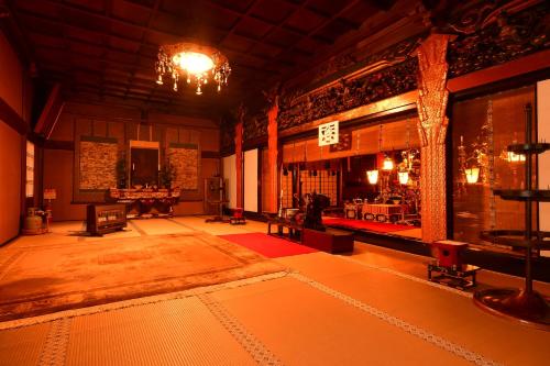 a living room with a chandelier and a large room with a table at 高野山 宿坊 龍泉院 -Koyasan Shukubo Ryusenin- in Koyasan