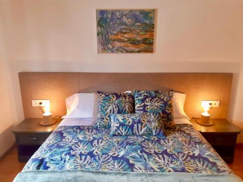 una camera da letto con un letto con due lampade sopra di Casa 4Estacions Palamós 3a linia Port Marina-Camí de Ronda - pàrquing a Palamós