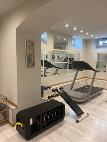a room with a gym with a treadmill and mirrors at Villa Promenade in Burgas City