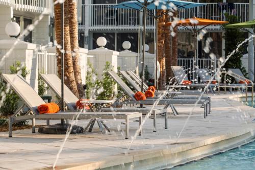 a pool with chairs and umbrellas in it at B Resort and Spa Located in Disney Springs Resort Area in Orlando