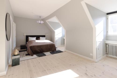 a white bedroom with a bed in a attic at 175SQM HIGH-END Luxury Apartment - Heart Of Copenhagen in Copenhagen