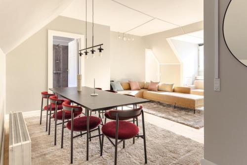 a dining room with a black table and red chairs at Luxury Apartment w Privat Rooftop Terrace - CPH C in Copenhagen