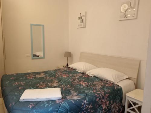 a bedroom with a bed with two pillows and a mirror at Pisacentro Guest House in Pisa