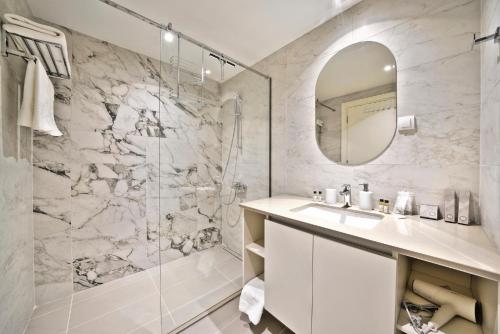 a bathroom with a shower and a sink and a mirror at Beograd na vodi - Belgrade Waterfront Riverside in Belgrade