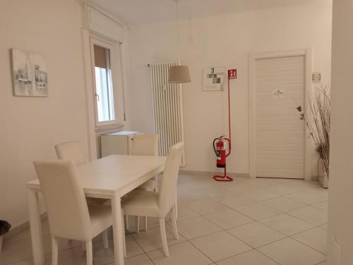 Un comedor blanco con una mesa y sillas blancas. en Pisacentro Guest House, en Pisa