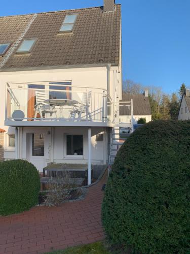 a white house with a deck and a patio at Komfort Ferienwohnung Kroemer Timmendorfer Strand in Timmendorfer Strand