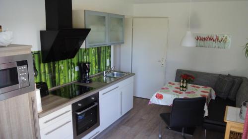 eine Küche mit einem Waschbecken und einem Tisch mit einem Tisch in der Unterkunft Ferienwohnung Hummel in Bad Buchau