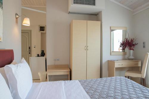 a bedroom with a bed and a cabinet and a desk at Zefyros Sea View Hotel in Platamonas