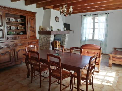 une salle à manger avec une table et des chaises et une cheminée dans l'établissement Villa Lélou, à Les Mignots