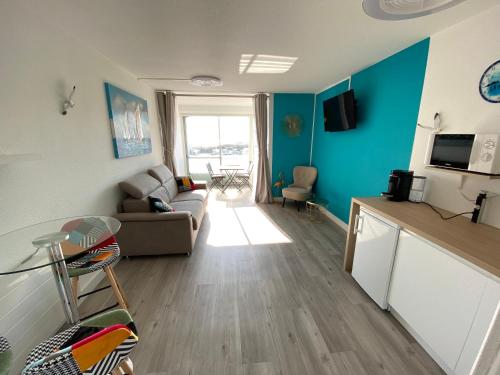 un salon avec un canapé et une table dans l'établissement Studio front de mer 'Le Soleillan', à La Grande Motte