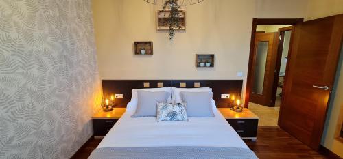 a bedroom with a large bed with two lamps at Apartamento Inma in Silleda