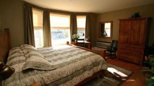 Un dormitorio con una cama grande y una ventana en Bayside Inn, en Parry Sound