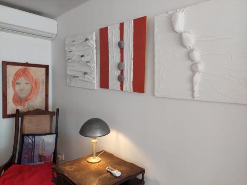 a room with a table with a lamp and some pictures at Villa des Galets in Saint-Pierre
