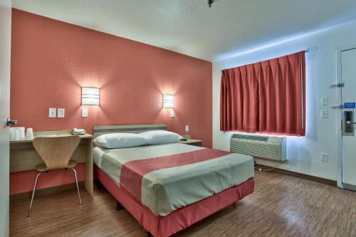 a hotel room with a large bed and a desk at Motel 6-Flagstaff, AZ - West - Woodland Village in Flagstaff