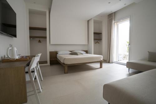 a bedroom with a bed and a desk and a window at Kalibia rooms and suites in Mazara del Vallo