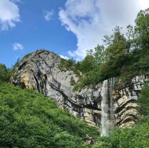 a waterfall on the side of a mountain at Appartement proche de la ville et du parc du Truchet in Saint-Claude