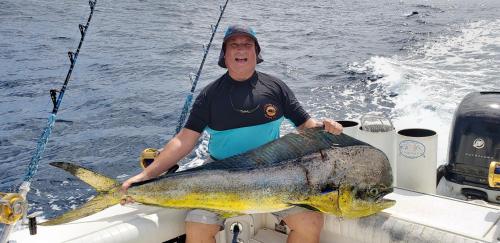 a man sitting on a boat holding a large fish at Boca Chica Bay Eco Lodge in Boca Chica
