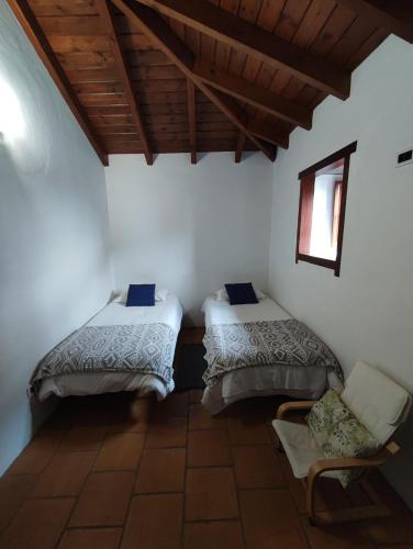 a room with two beds and a chair in it at La Fortaleza in Erjos-El Tanque