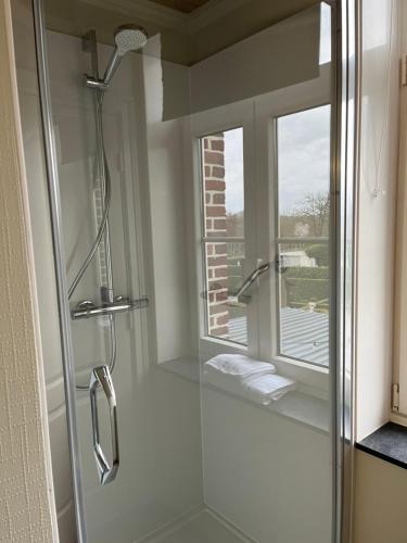 a bathroom with a glass shower with a window at Gasthof De Statie in Wilderen