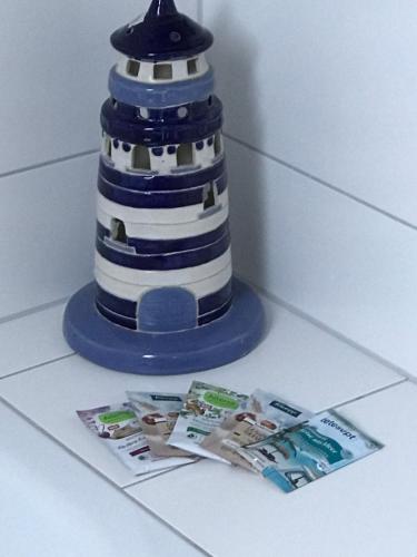 a blue and white lighthouse toy next to a magazine at Feriendomizil Dornum Haus Margarete mit Wallbox in Dornum