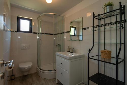 a bathroom with a shower and a toilet and a sink at Kamp Mara in Pakoštane