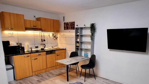 eine kleine Küche mit einem Tisch und einem TV an der Wand in der Unterkunft MsApartment Stylish wohnen in STUTTGART in Stuttgart