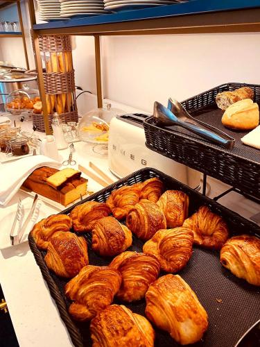 a bunch of croissants and other baked goods on a counter at Cèdre Beaune, A Beauvallon Hotel & Spa in Beaune