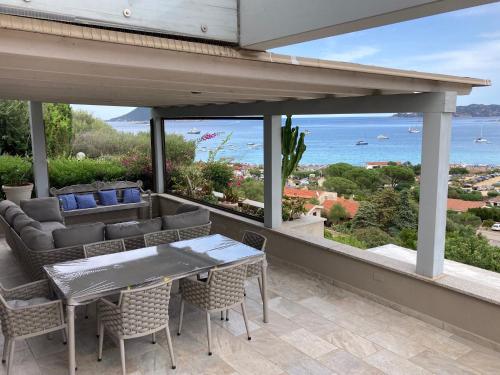 a patio with a table and chairs and a view of the ocean at Molarotto in Porto Taverna