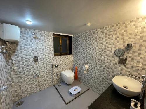 un bagno con wc, lavandino e doccia di Ola Agro Riverside Villa in Malvan, Dhamapur, Sindhudurg a Pendur