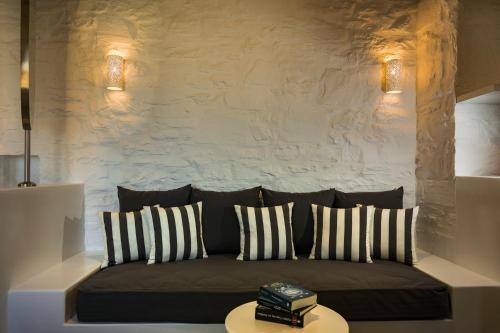 a living room with a couch with pillows and a table at Maris Private Residence in Chora Folegandros