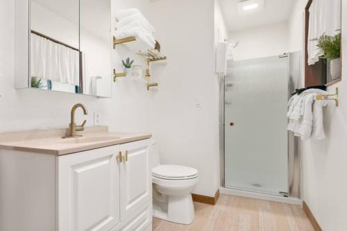a white bathroom with a toilet and a shower at Riverside Retreat in Rhododendron
