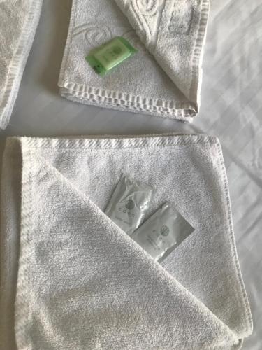 a white towel with two remote controls on a bed at Canasta Hotel in Blackpool