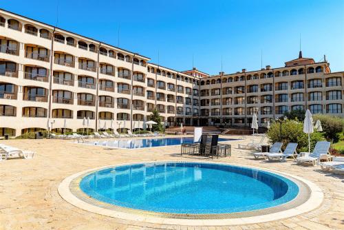 un hotel con piscina frente a un edificio en Menada Nestinarka Apartments, en Tsarevo