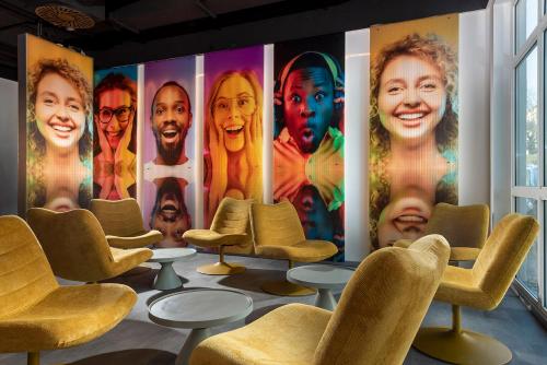 a waiting room with chairs and posters of women at ibis Styles Berlin Treptow in Berlin