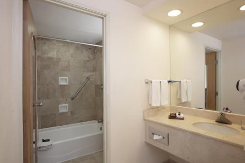 a bathroom with a tub and a sink and a shower at Fiesta Inn Veracruz Malecon in Veracruz