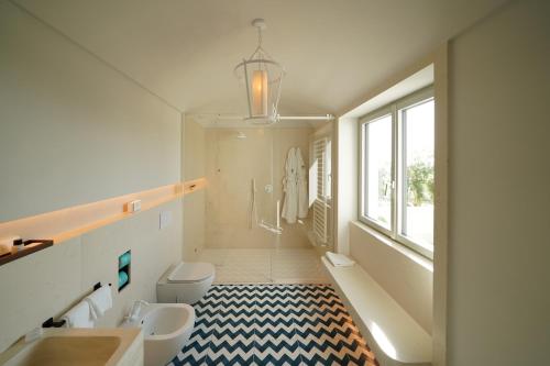 bagno con lavandino, servizi igienici e finestra di Dimora dei Lari a Bacoli