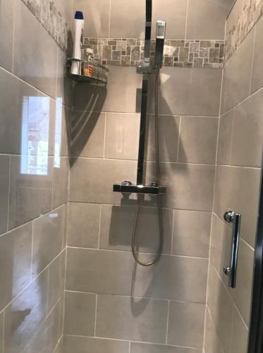 une salle de bain avec une douche avec un tuyau dans l'établissement Logement à Brive, proche centre-ville et gare, avec climatisation - internet fibre - Stationnements gratuit, à Brive-la-Gaillarde