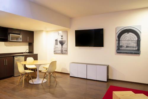 薩卡特卡斯的住宿－薩卡特卡斯節日酒店，客厅配有桌子和墙上的电视