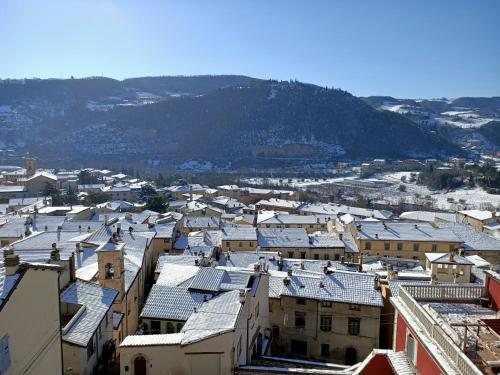 a city with snow covered roofs and a mountain at La Corte Alta in Fossombrone