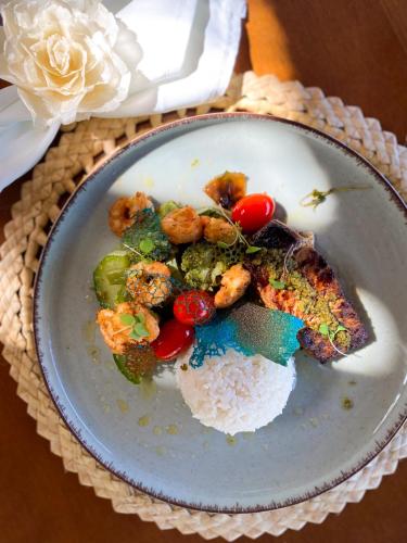 a plate of food with vegetables and rice on a table at Pousada o Casarão in São Miguel dos Milagres
