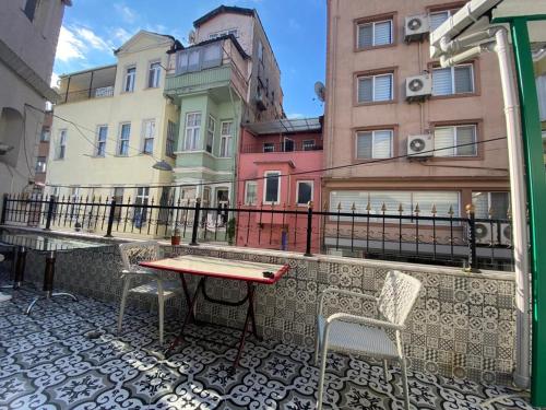 een balkon met een tafel en stoelen en gebouwen bij Old City Pansiyon in Istanbul