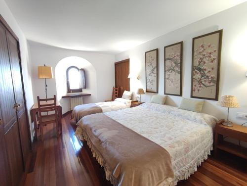 a bedroom with two beds and a table and chairs at Casa Rural Erletxe in Laguardia