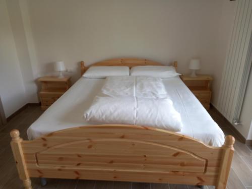 - un lit en bois dans une chambre avec 2 tables de chevet dans l'établissement Strada Facendo, à Collebrincioni