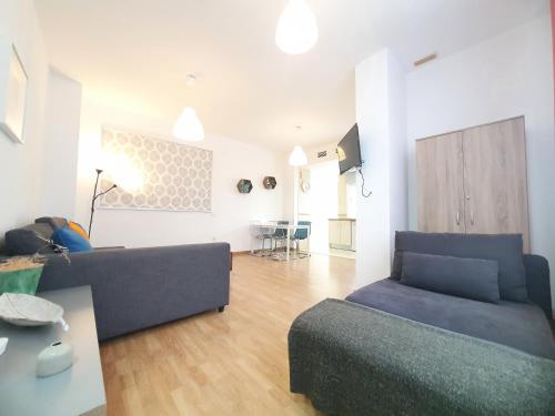 un salon avec un canapé et une table dans l'établissement Ático centro "El diván azul", à Malaga