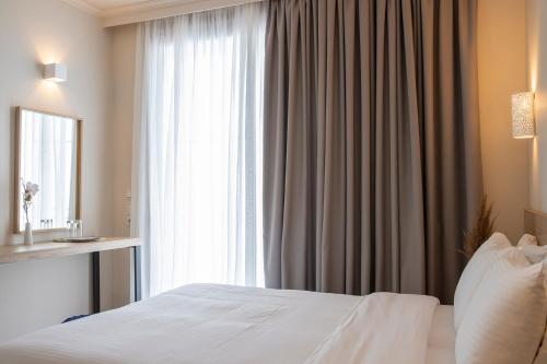 a bedroom with a bed and a large window at Zefyros Sea View Hotel in Platamonas