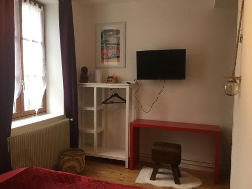 a living room with a television on a wall at L auberge du lion d or in Nanteuil-sur-Marne